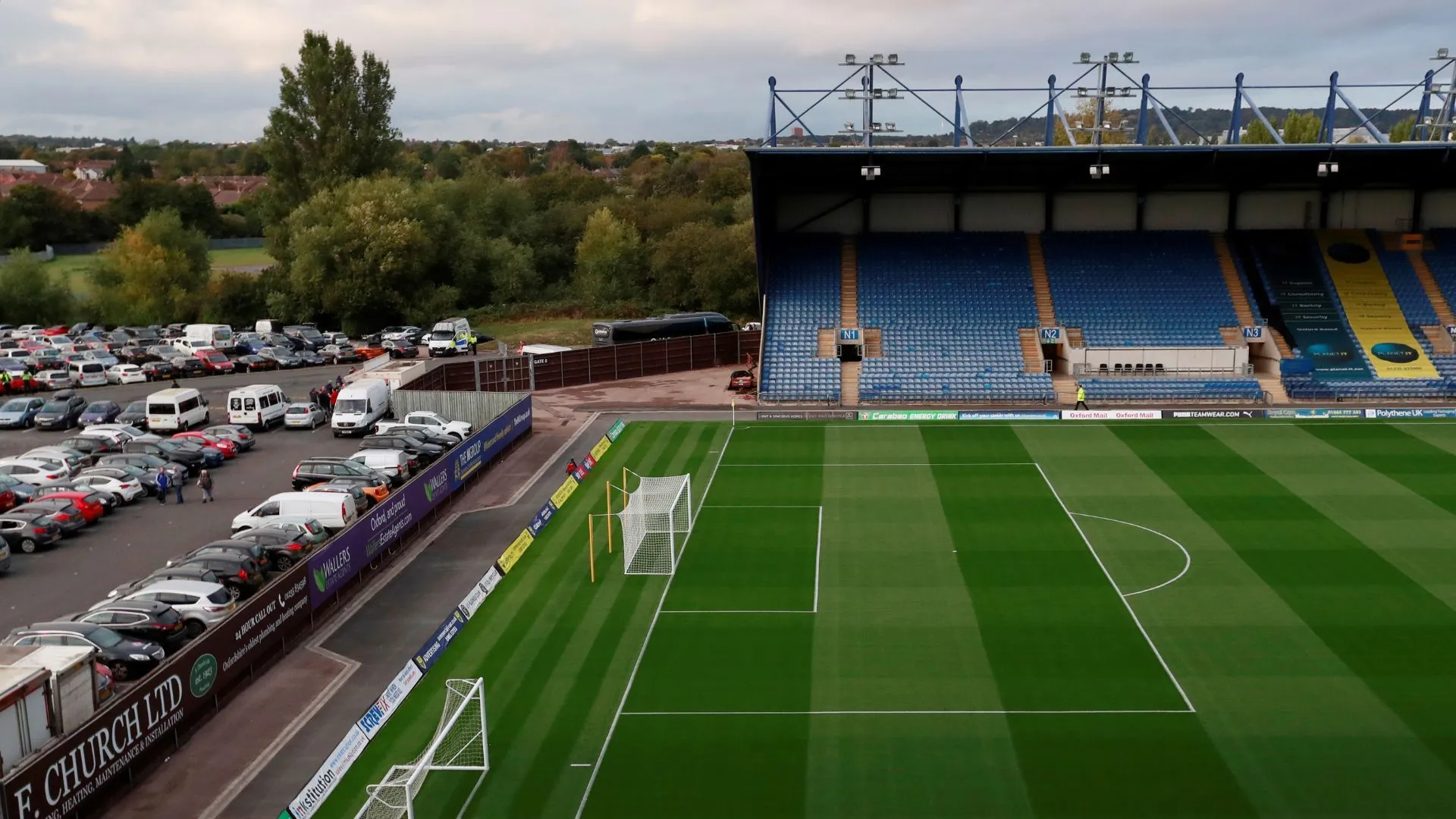 Kassam Stadium, mái nhà của Oxford United, với áo đấu sân nhà 2025/26